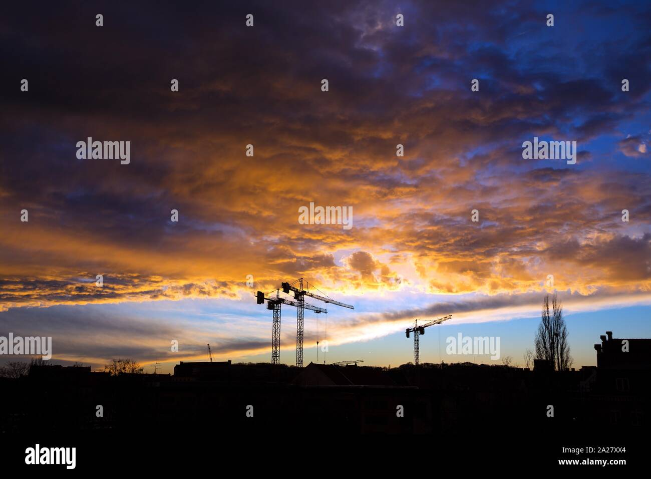 tower cranes against a stormy sky Stock Photo - Alamy
