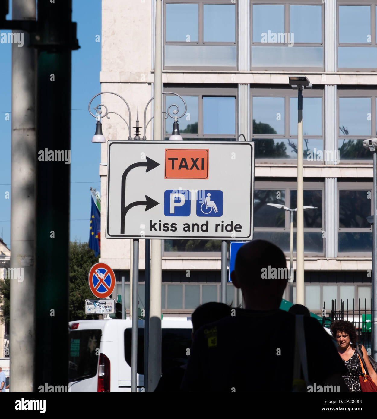 Really odd, funny directional road sign near Rome railway station highlighting taxis, parking and disabled access with the message 'Kiss and Ride' Stock Photo