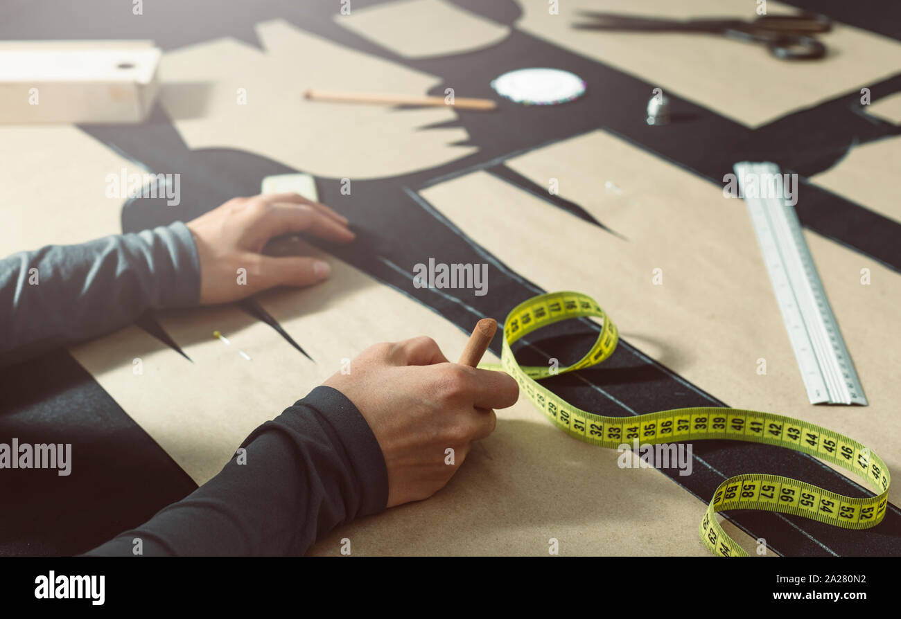 The tailor lays out the pattern on the fabric in the studio. The cutter ...