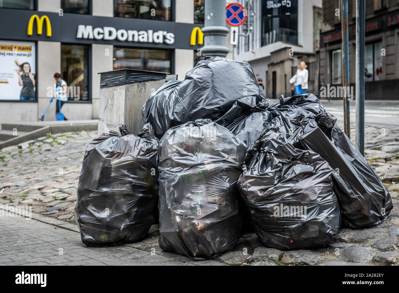https://c8.alamy.com/comp/2A282EY/pile-of-plastic-bags-full-of-garbage-in-front-of-a-fast-food-restaurant-2A282EY.jpg