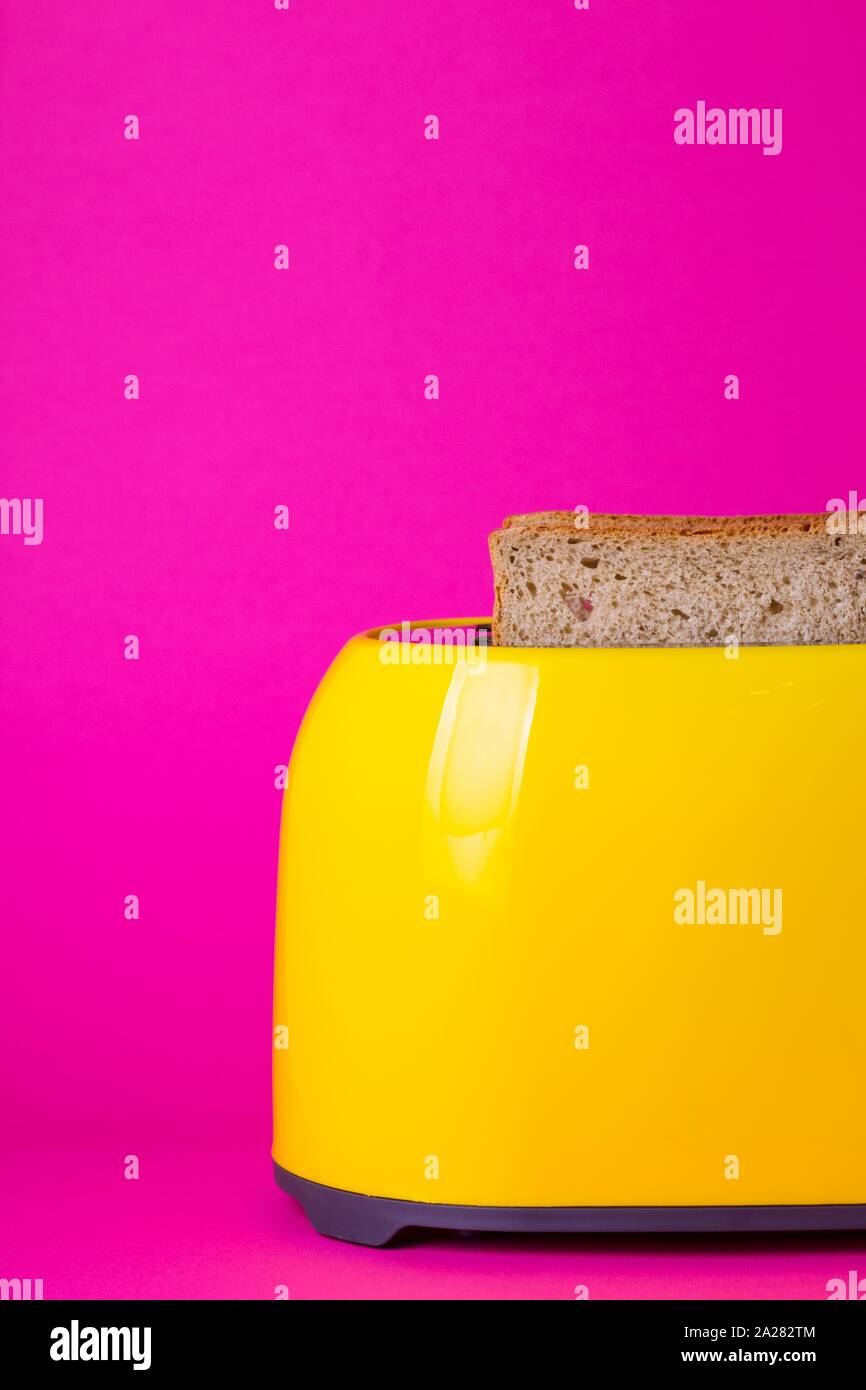 bright, fun breakfast. yellow toaster on a pink background Stock Photo
