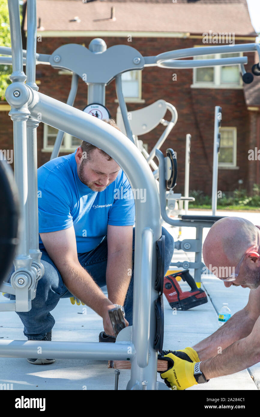 Detroit, Michigan - Volunteers from Cooper Standard install exercise equipment in a new community park in the Morningside neighborhood. Stock Photo