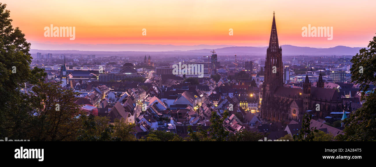 Germany, XXL panorama of skyline of freiburg im breisgau by night after sunset with red sky in magical twilight from above Stock Photo