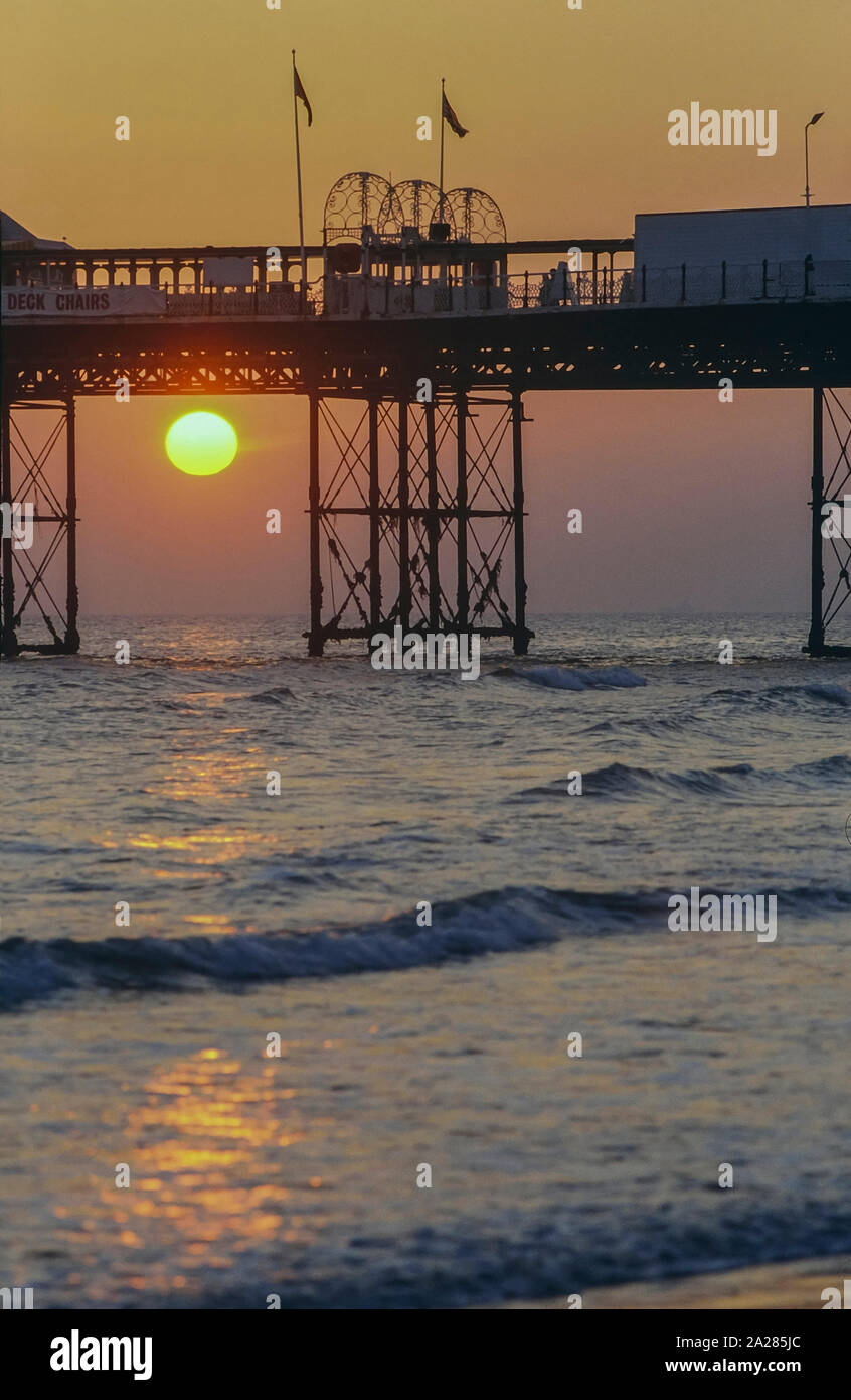 Sunset under the Palace pier, Brighton, East Sussex, England, UK. Circa 1980's Stock Photo