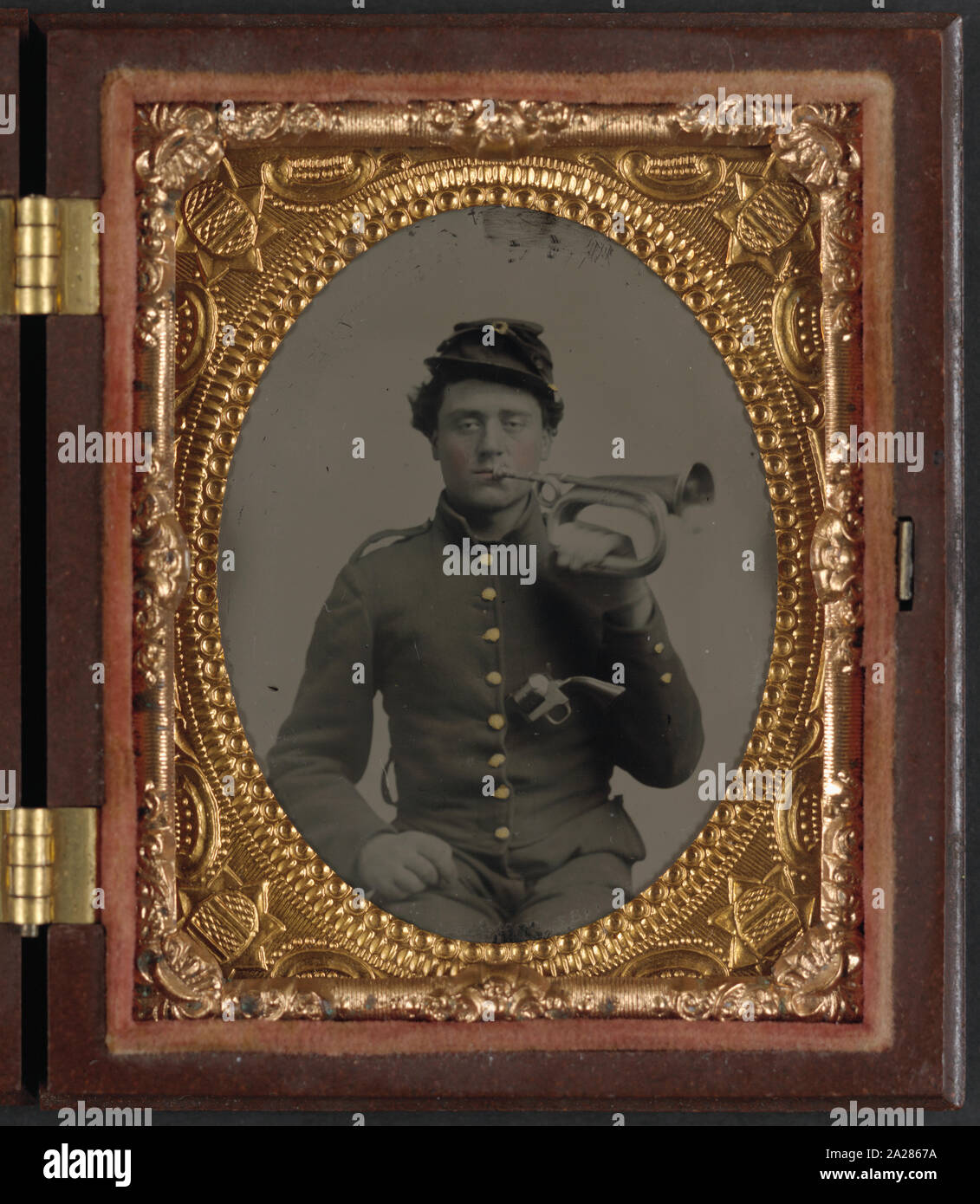 Private James E. Staley of Band Company, 9th Indiana Infantry Regiment, and Company B, 1st Indiana Heavy Artillery Regiment, holding a bugle to his mouth and carrying a revolver in his jacket Stock Photo