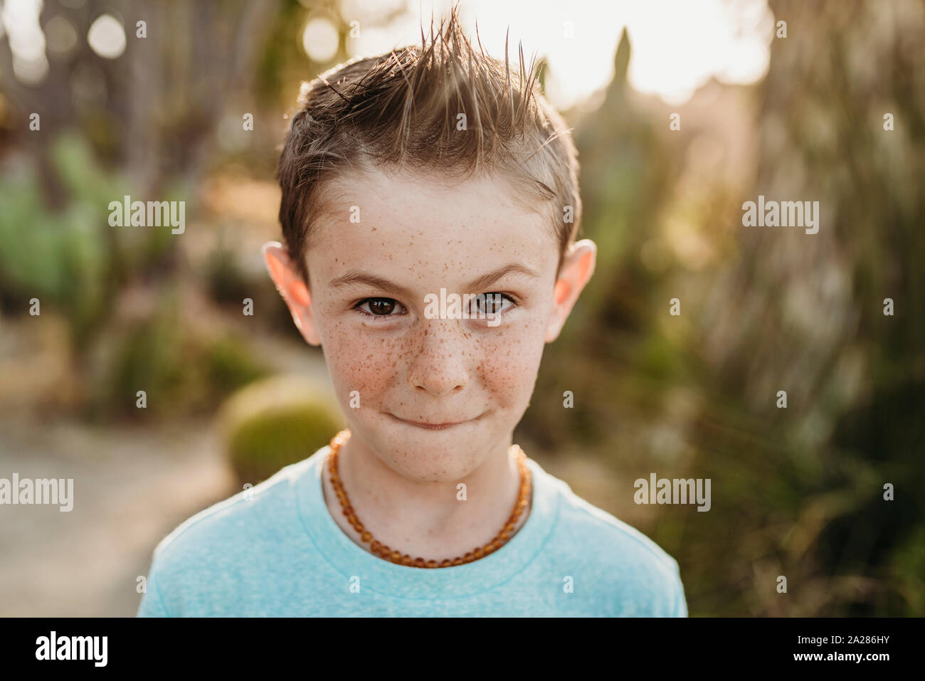 Close up portrait of cute young boy with freckles making serious face Stock Photo