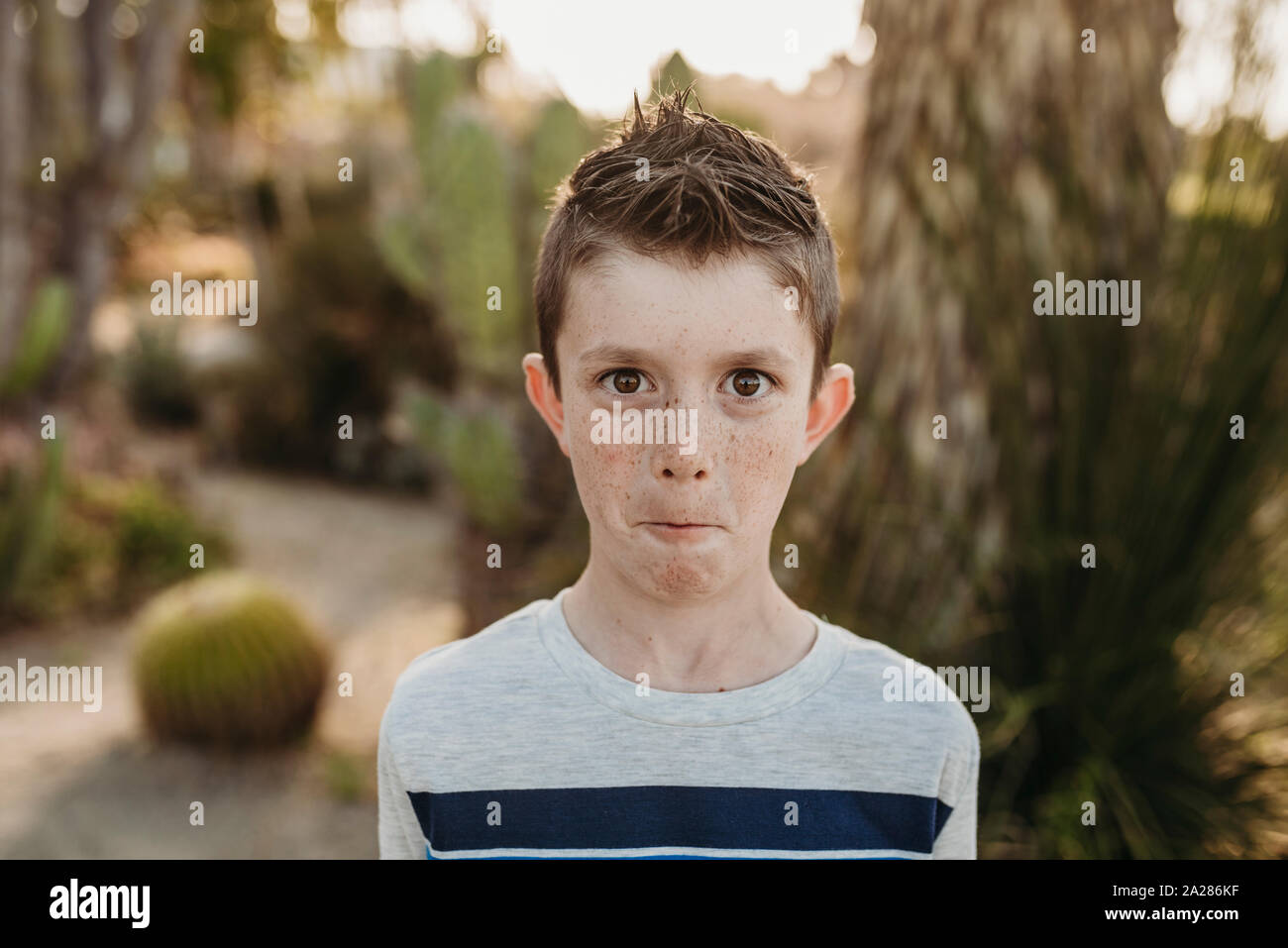 Close up portrait of cute young boy with freckles making funny face Stock Photo