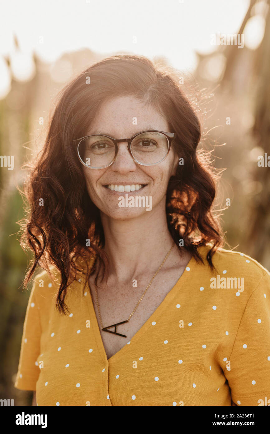 Headshot portrait of mid adult female mother with glasses, outside Stock Photo