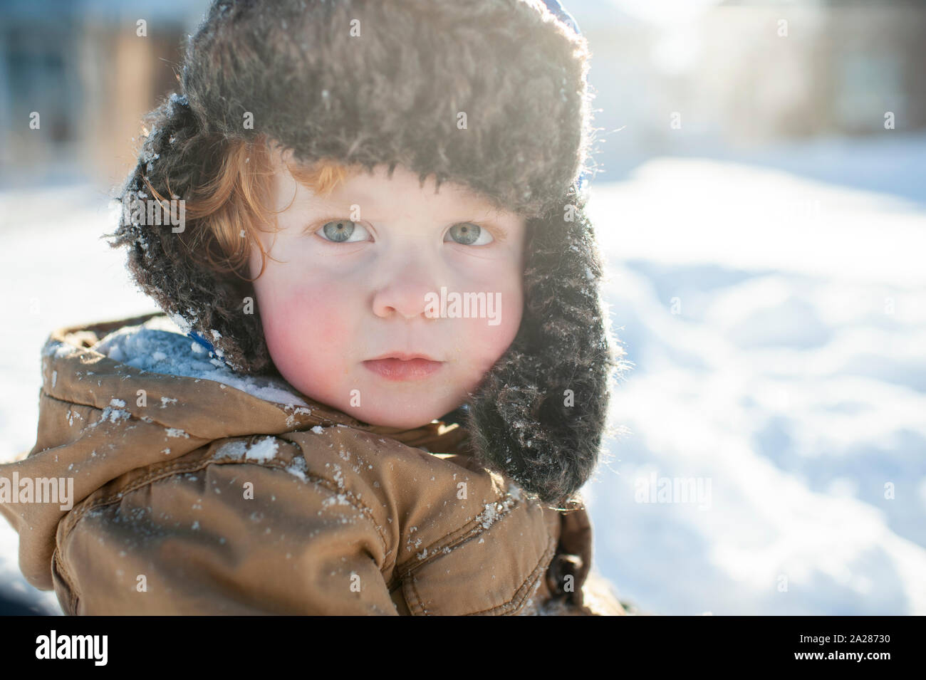 Portrait of toddler boy in winter clothes and hat out in the snow Stock Photo