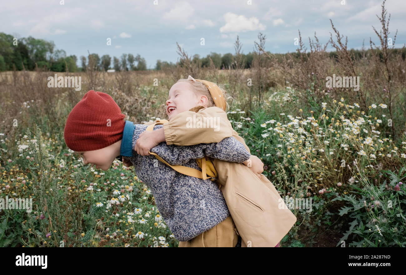 brother and sister hugging and laughing whilst playing outside Stock ...