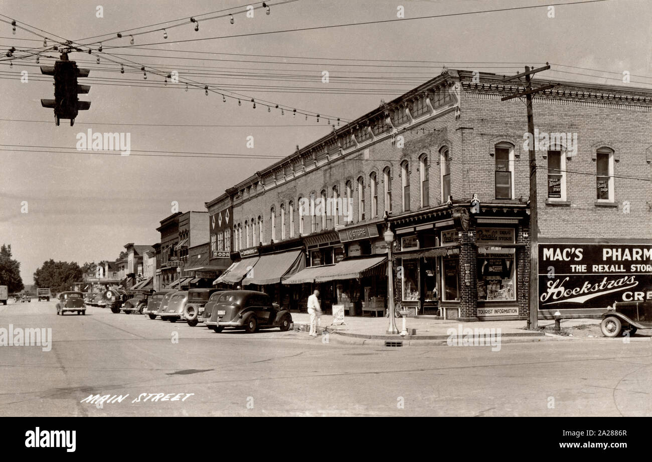 Main Street, Evart, Michigan,  1930s-1940s showing shops and automobiles of the period. Stock Photo