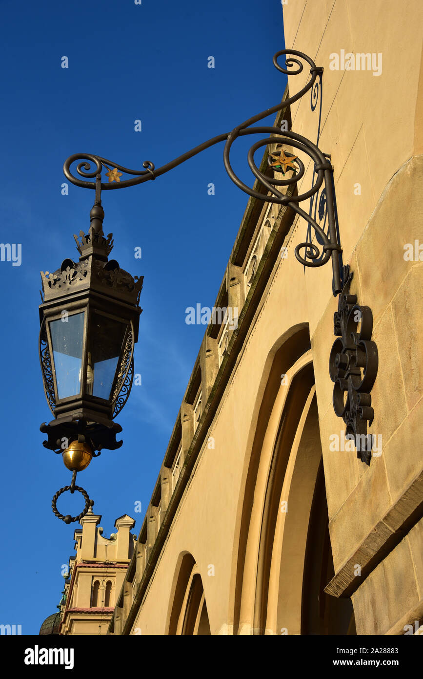 Decorative wrought-iron lamp hangs from Krakow's Cloth Hall, one of the oldest shopping malls in the world, Poland, Europe. Stock Photo