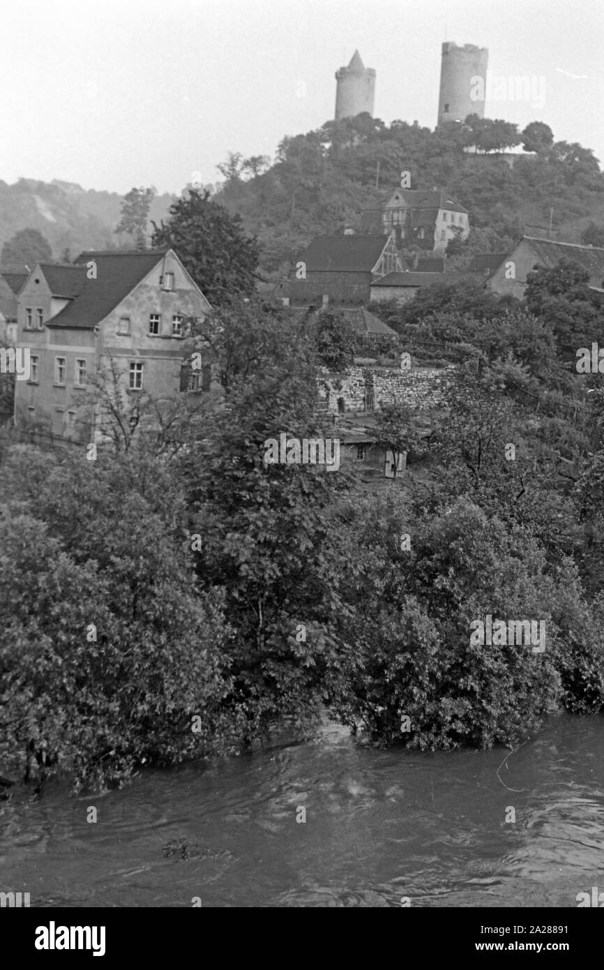 Die Ortschaft Saaleck unterhalb der Burg Saaleck im Burgenlandkreis, Deutschland 1950. The village of Saaleck with Saaleck castle on a hill, Germany 1950. Stock Photo