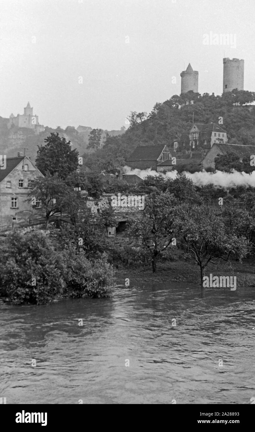 Die Ortschaft Saaleck unterhalb der Burg Saaleck im Burgenlandkreis, Deutschland 1950. The village of Saaleck with Saaleck castle on a hill, Germany 1950. Stock Photo