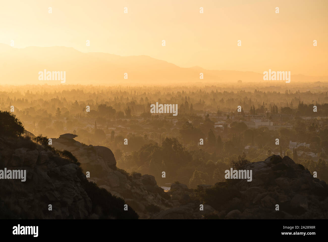 Hazy morning sunshine above West San Fernando Valley neighborhoods in the city of Los Angeles, California.  The San Gabriel Mountains are in the backg Stock Photo
