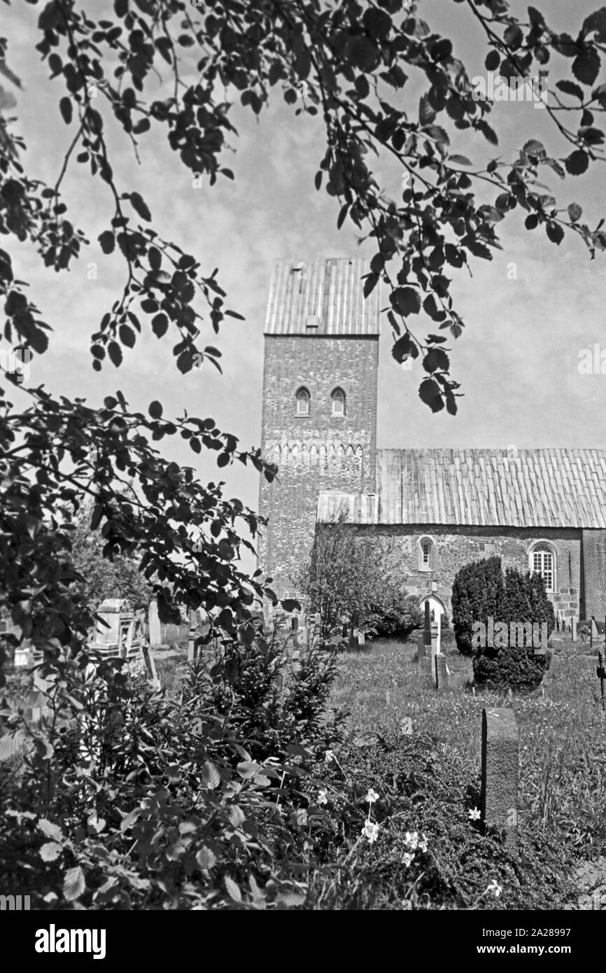 Evangelische Sankt Laurentii Kirche mit Kirchhof in Süderende auf der Insel Föhr, Deutschland 1960er Jahre. Protestant Saint Laurentii church with churchyard at Suederende on Foehr island, Germany 1960s. Stock Photo