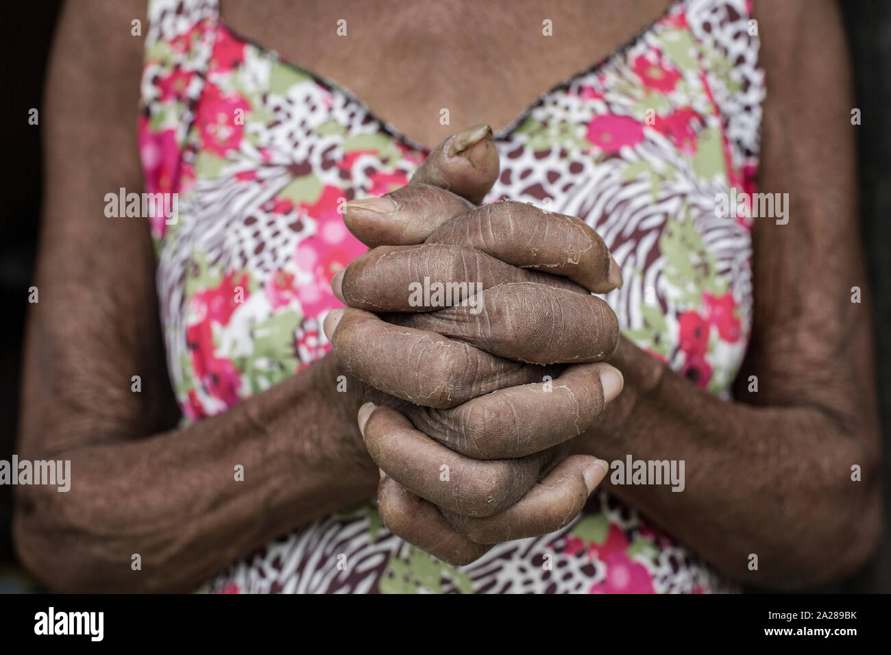Senior Afro-Brazilian woman with joined hands Stock Photo