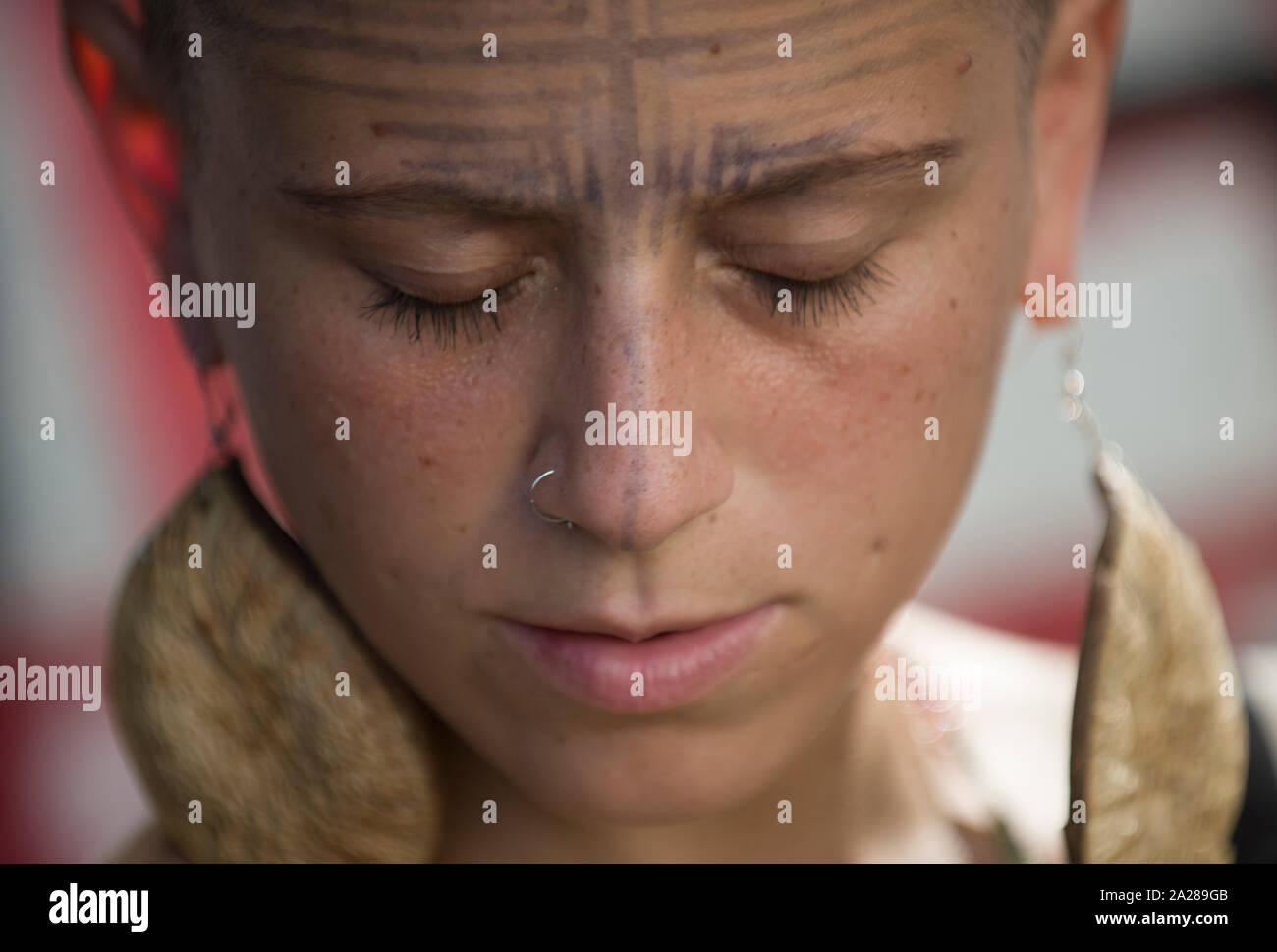 Young Brazilian woman with indigenous earrings and face painting Stock Photo