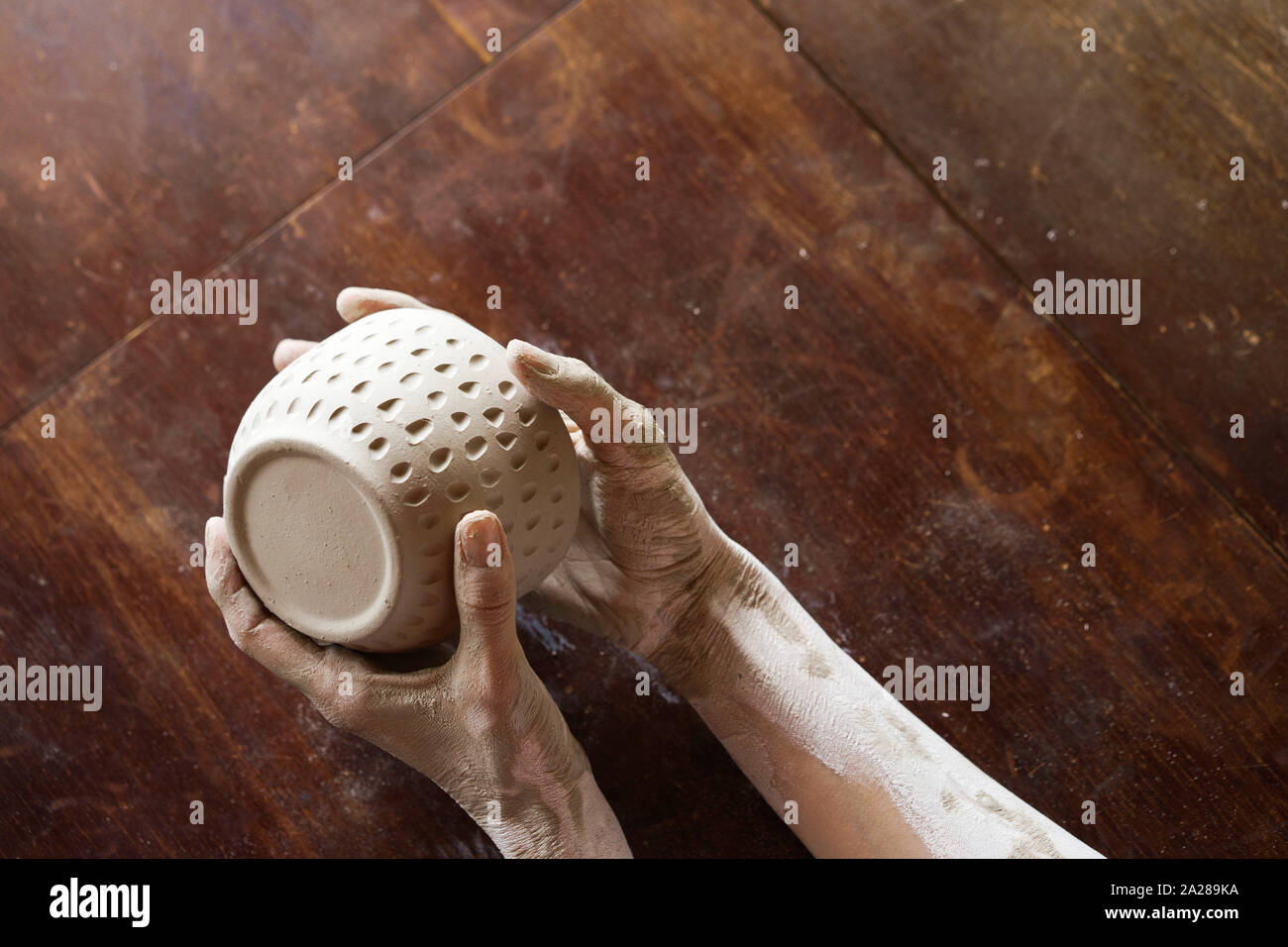 Female hands hold a wet clay bowl. Pottery making Stock Photo Alamy