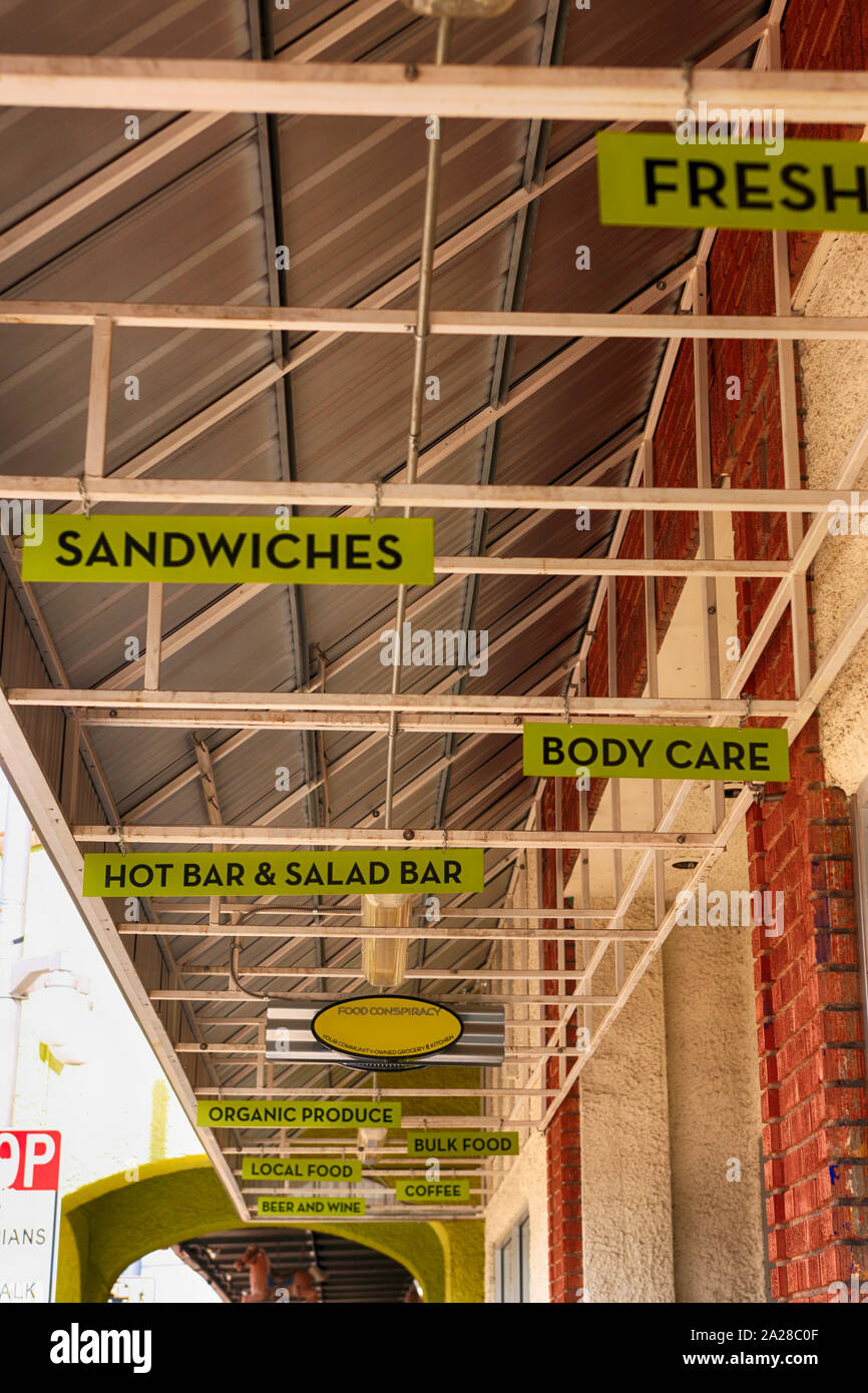 Overhead signs promoting fresh, sandwiches, body care, hot bar & salad bar and more over a sidewalk in Tucson AZ Stock Photo