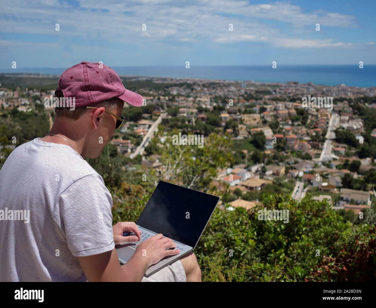 Freelancer, a man works in nature, with a beautiful landscape in front of him, work by the sea, work in pleasure Stock Photo