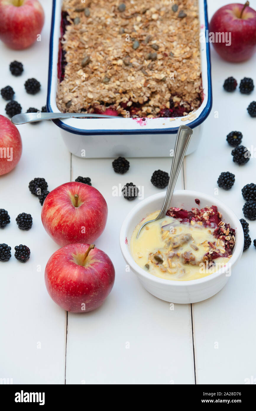 Homemade Blackberry and apple crumble and custard with a tablespoon
