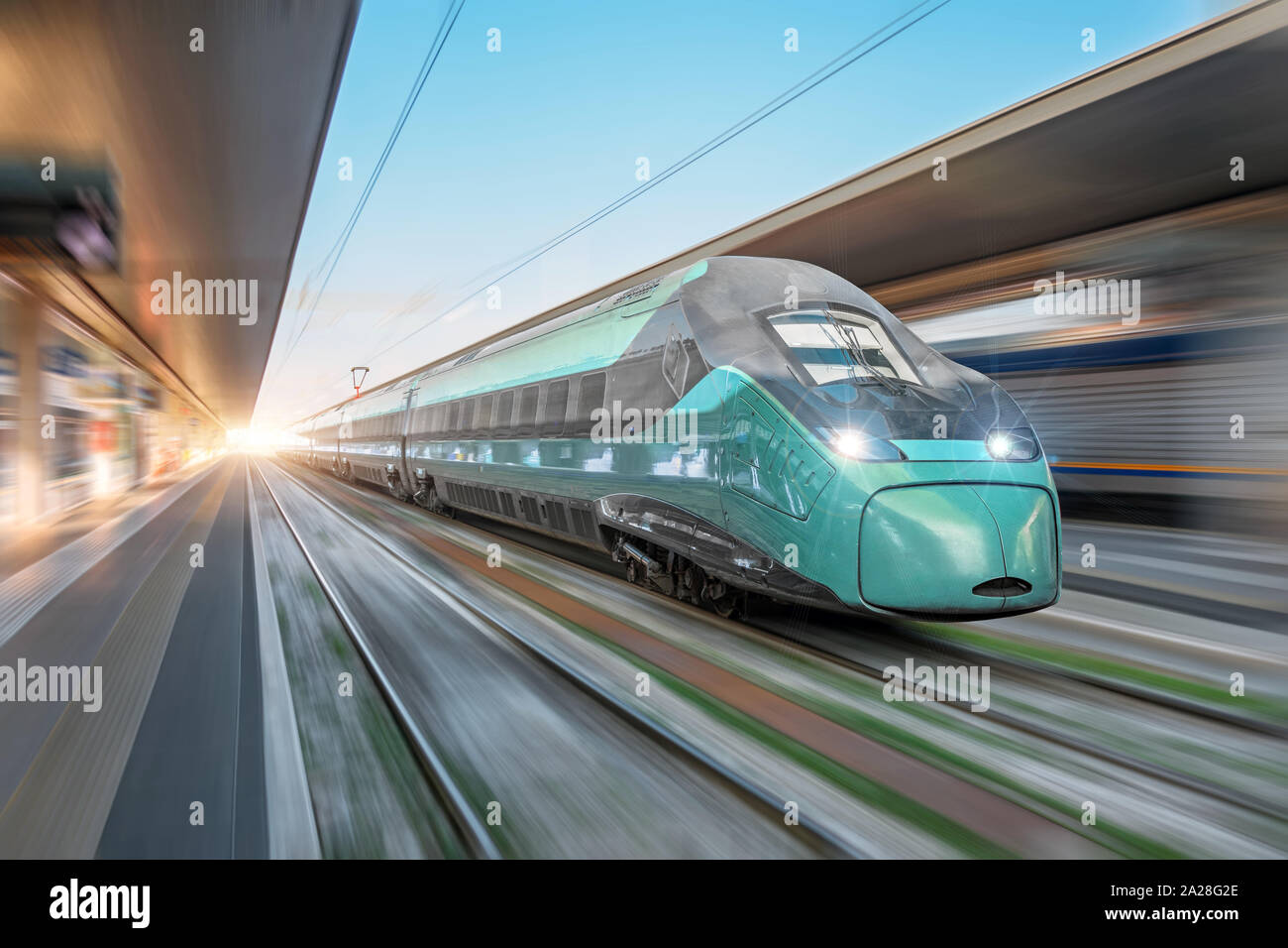 High speed train passing near the passenger station in the city. Stock Photo