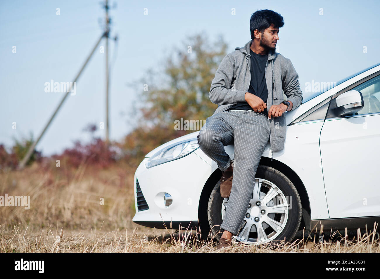 Indian man at casual wear posed near white car Stock Photo - Alamy