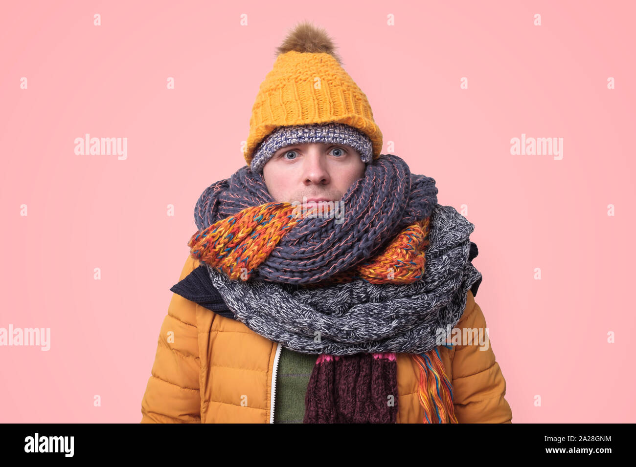 Handsome caucasian funny man in several hats and scarfs. Stock Photo