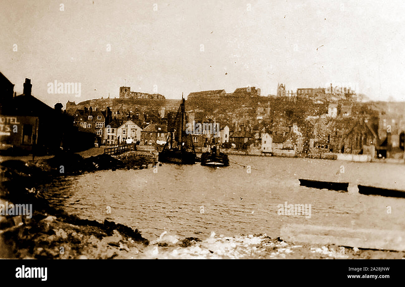 A very old and rare photo of the 'Dark End' of  Whitby, Yorkshire, UK before the Dock End area was built upon. To the left is the Angel Vaults, now the Angel Hotel. In the distance  over the River Esk can be seen the Parish Church, Abbey, St Michael's Church and Church Street. The view is from what is now the railway station Stock Photo