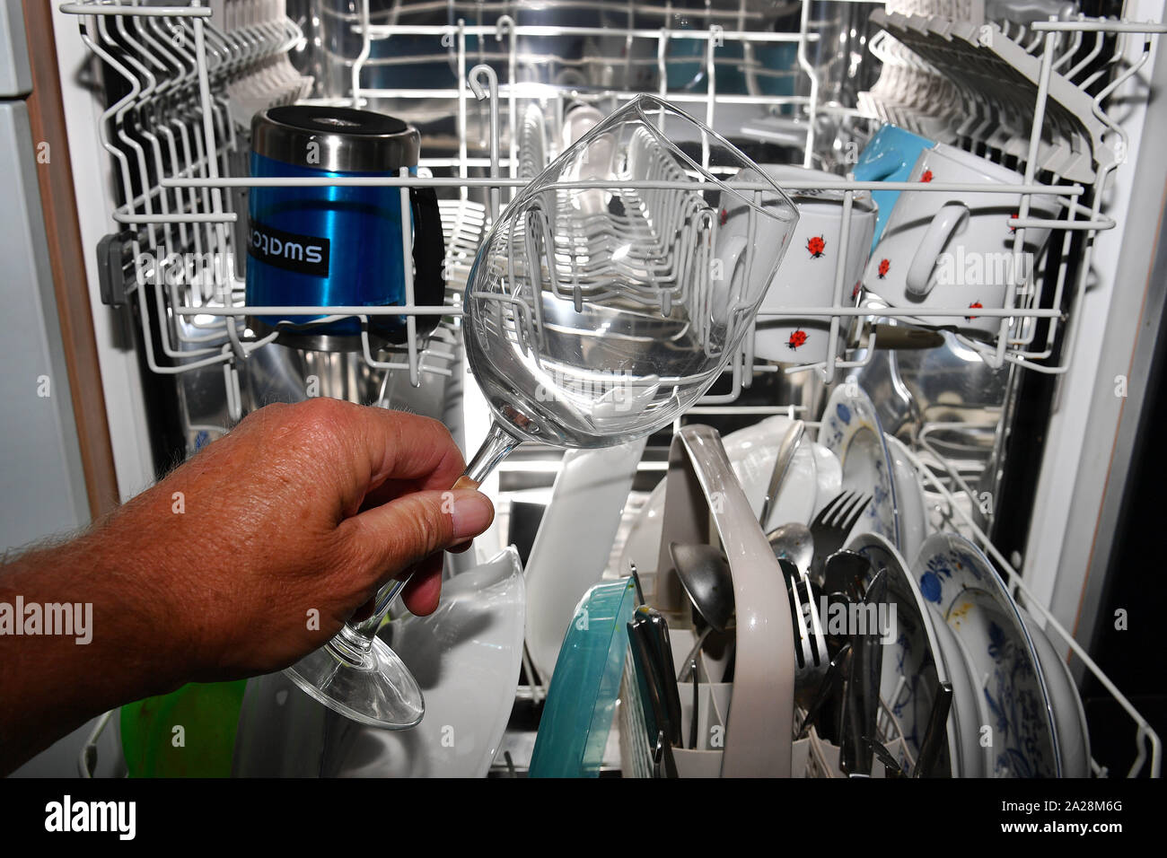 Munich, Deutschland. 01st Oct, 2019. A wine glass is taken from a Spulmschanie and inspected for its cleanliness, washing result, clean, cleaning, Spülergebnis. Full dishwasher, dishes, washing dishes, dishwasher, crockery basket, kitchen utensils, household, household appliance, play, rinse, clean, full, open flap. | usage worldwide Credit: dpa/Alamy Live News Stock Photo