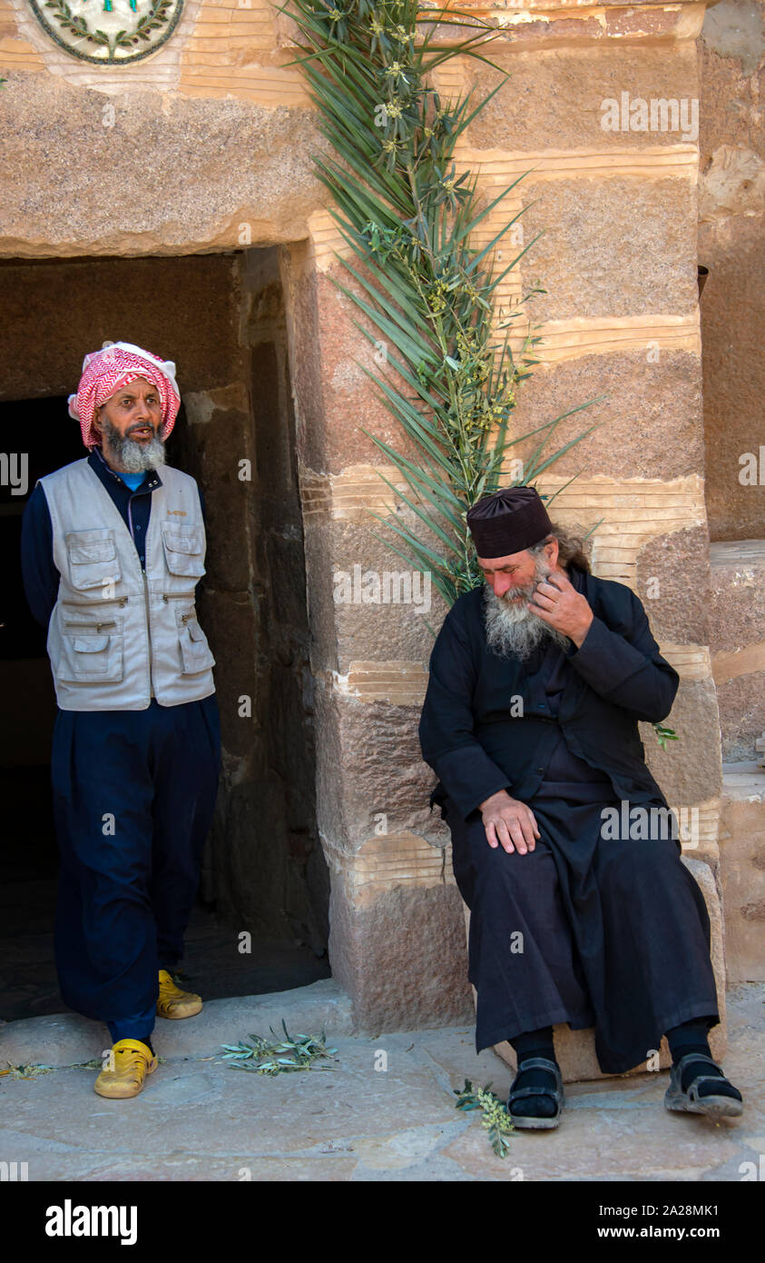 A monk living at Saint Catherine's Monastery having a conversation with a pilgrim visiting the holy site, listed on UNESCO as a world heritage site Stock Photo