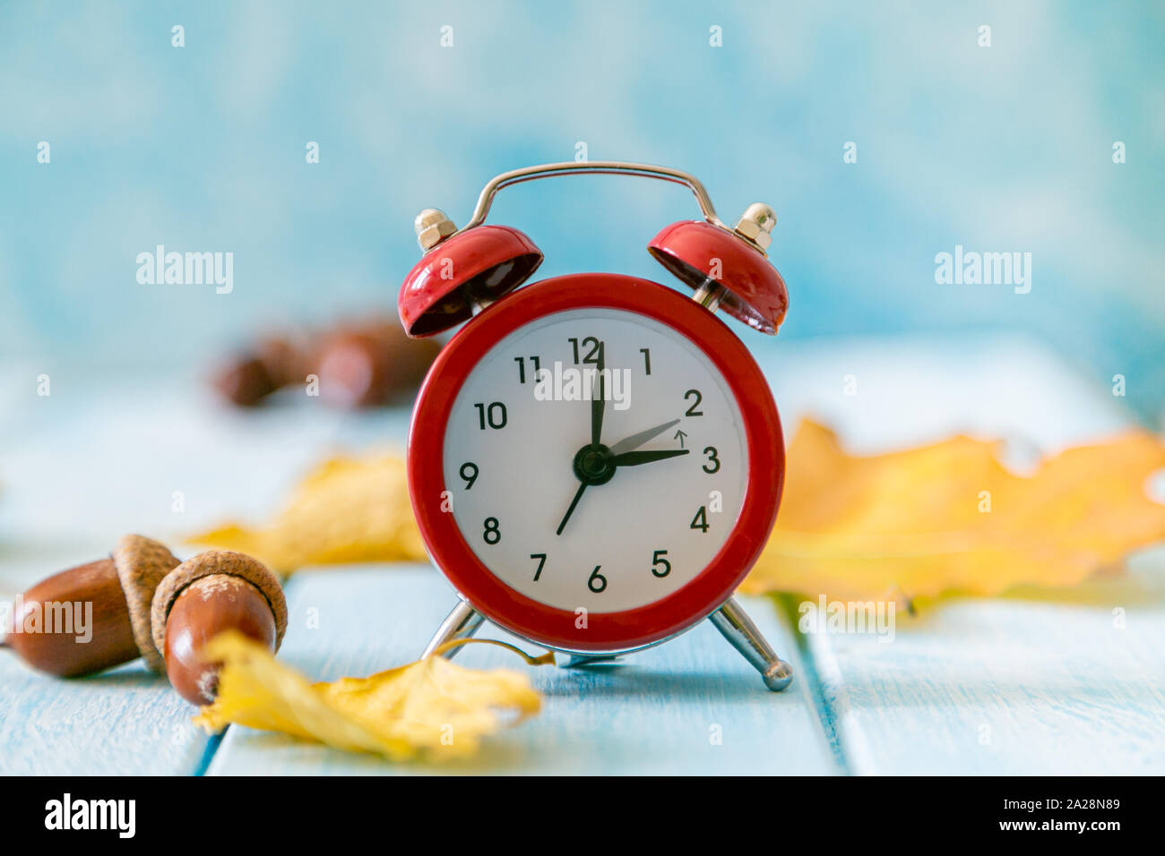 Autumn time change concept red alarm clock on wood background Stock