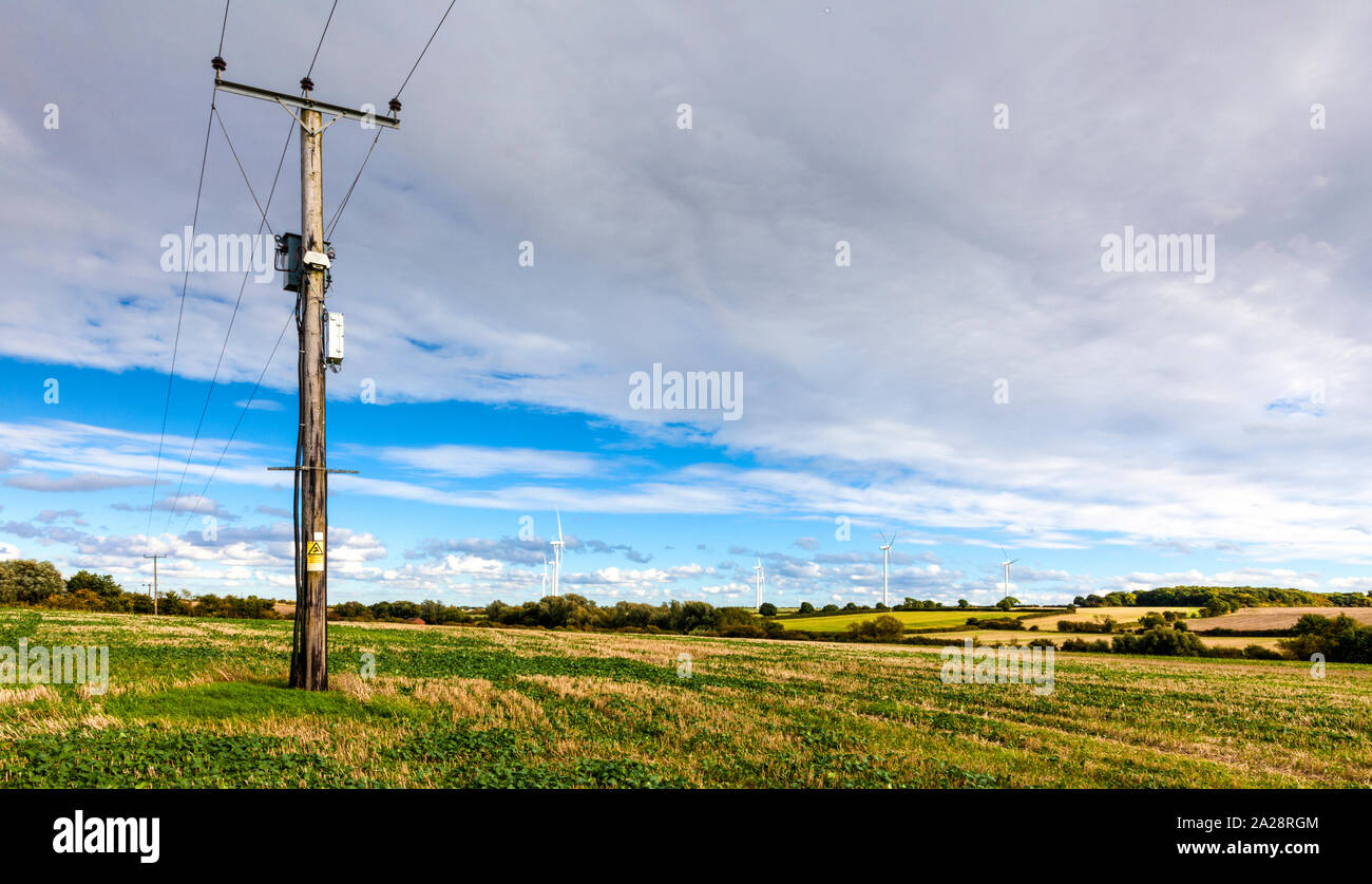 Electricity pole in a green field Stock Photo - Alamy