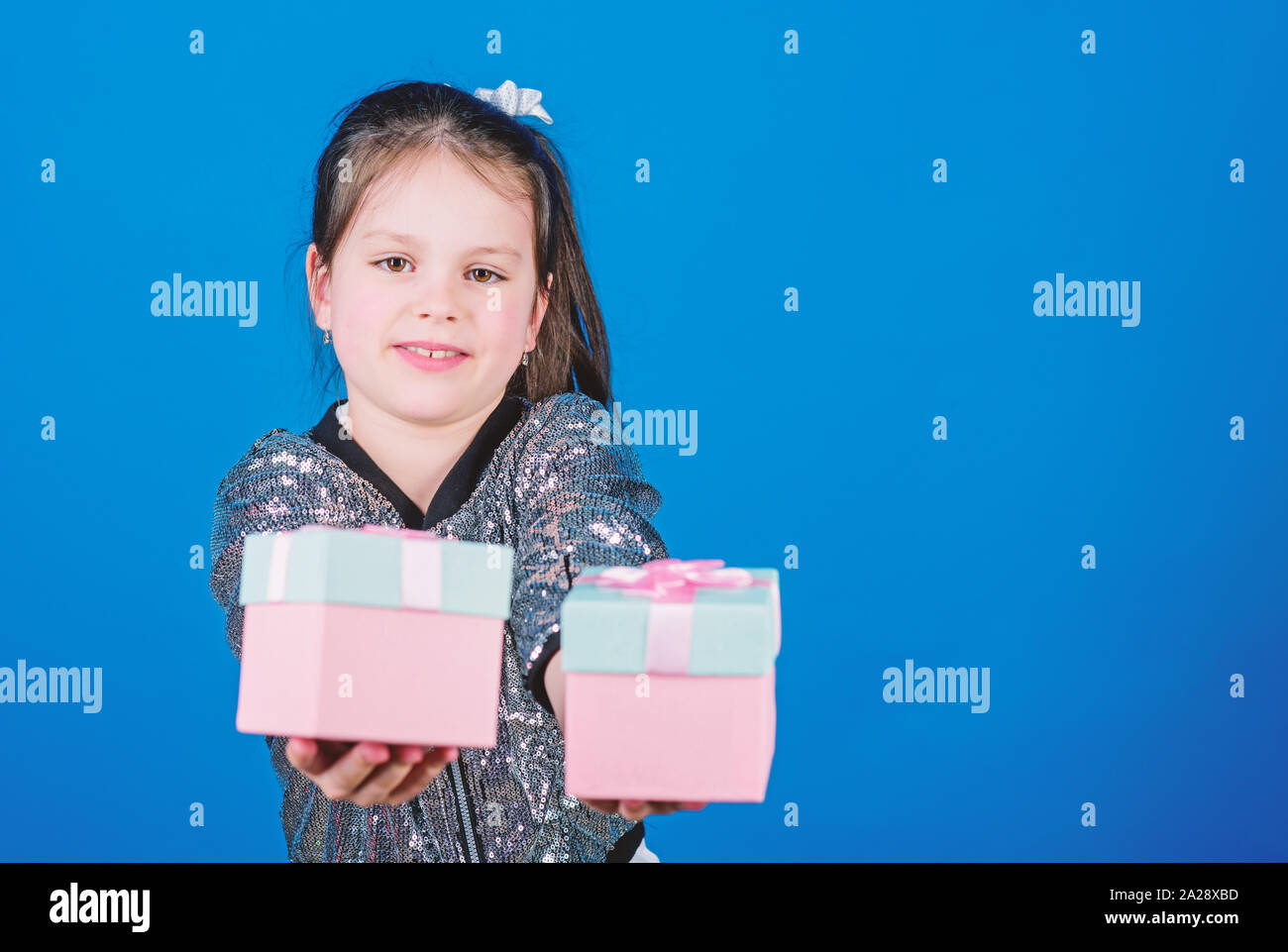 Girl with gift boxes blue background. Black friday. Shopping day. Cute child carry gift boxes. Surprise gift box. Birthday wish list. World of happiness. Special happens every day. Choose one. Stock Photo