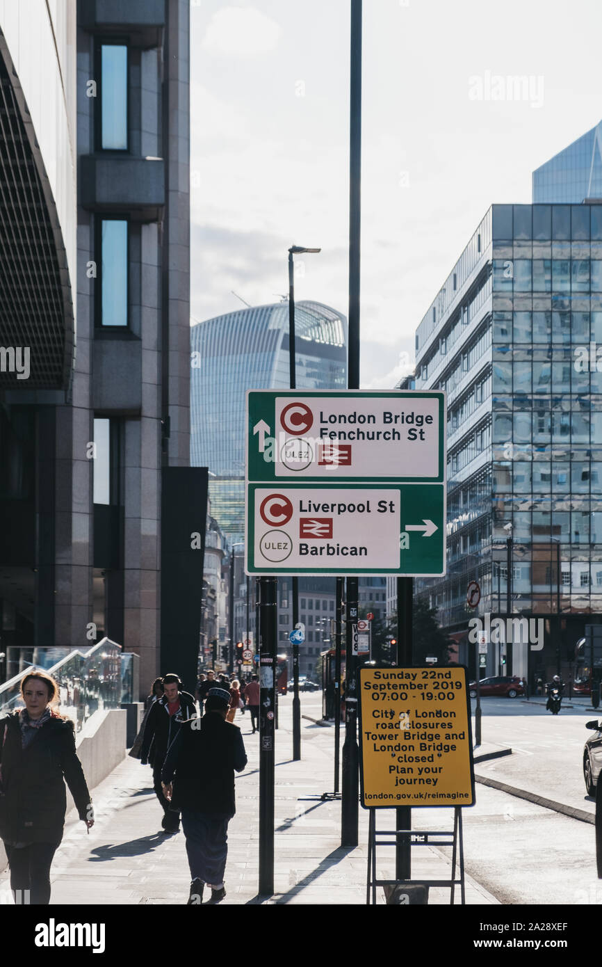 London, UK - September 7,2019:People walking by Ultra Low Emission Zone (ULEZ) and Congestion Charge signs on a street in London. ULEZ was introduced Stock Photo