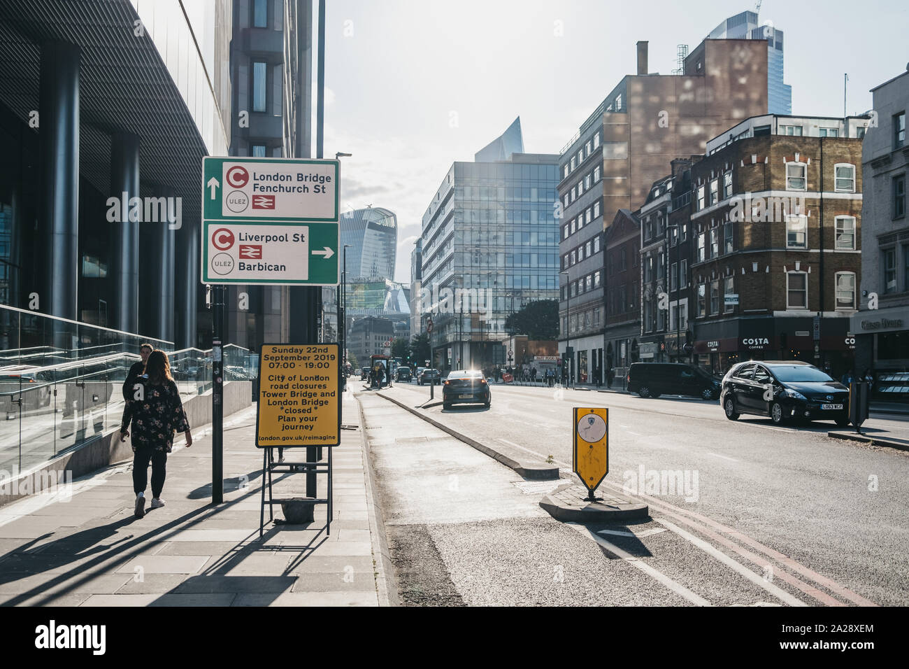 London, UK - September 7,2019:People walking by Ultra Low Emission Zone (ULEZ) and Congestion Charge signs on a street in London. ULEZ was introduced Stock Photo