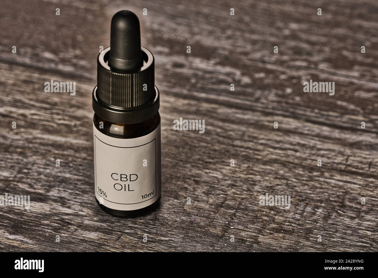 small bottle with CBD oil on wooden surface Stock Photo