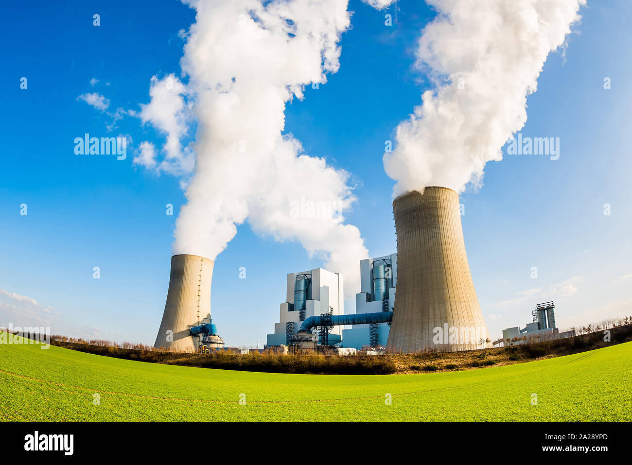 Power plant with two smoking cooling towers Stock Photo