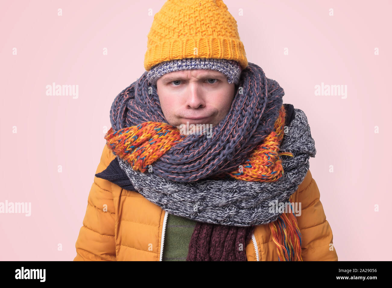 Handsome caucasian funny man in several hats and scarfs. Stock Photo