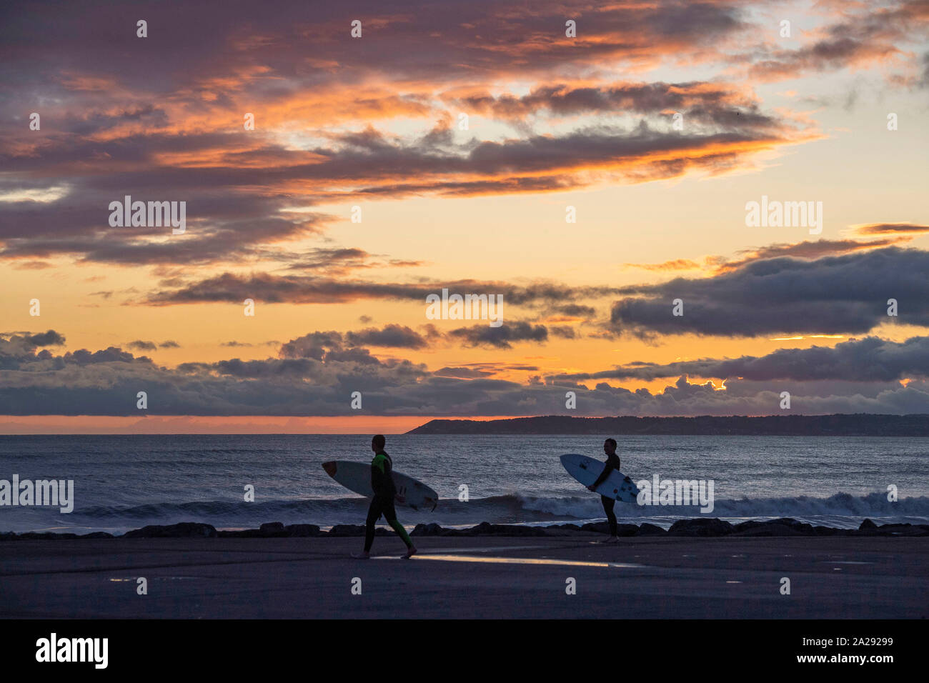 Port Talbot, UK. 01st Oct, 2019. Surfers  at Aberavon Beach in Port Tallbot watch as the sun goes down across the water at Swansea this evening duting a break in the wet and windy weather. Credit: Phil Rees/Alamy Live News Stock Photo