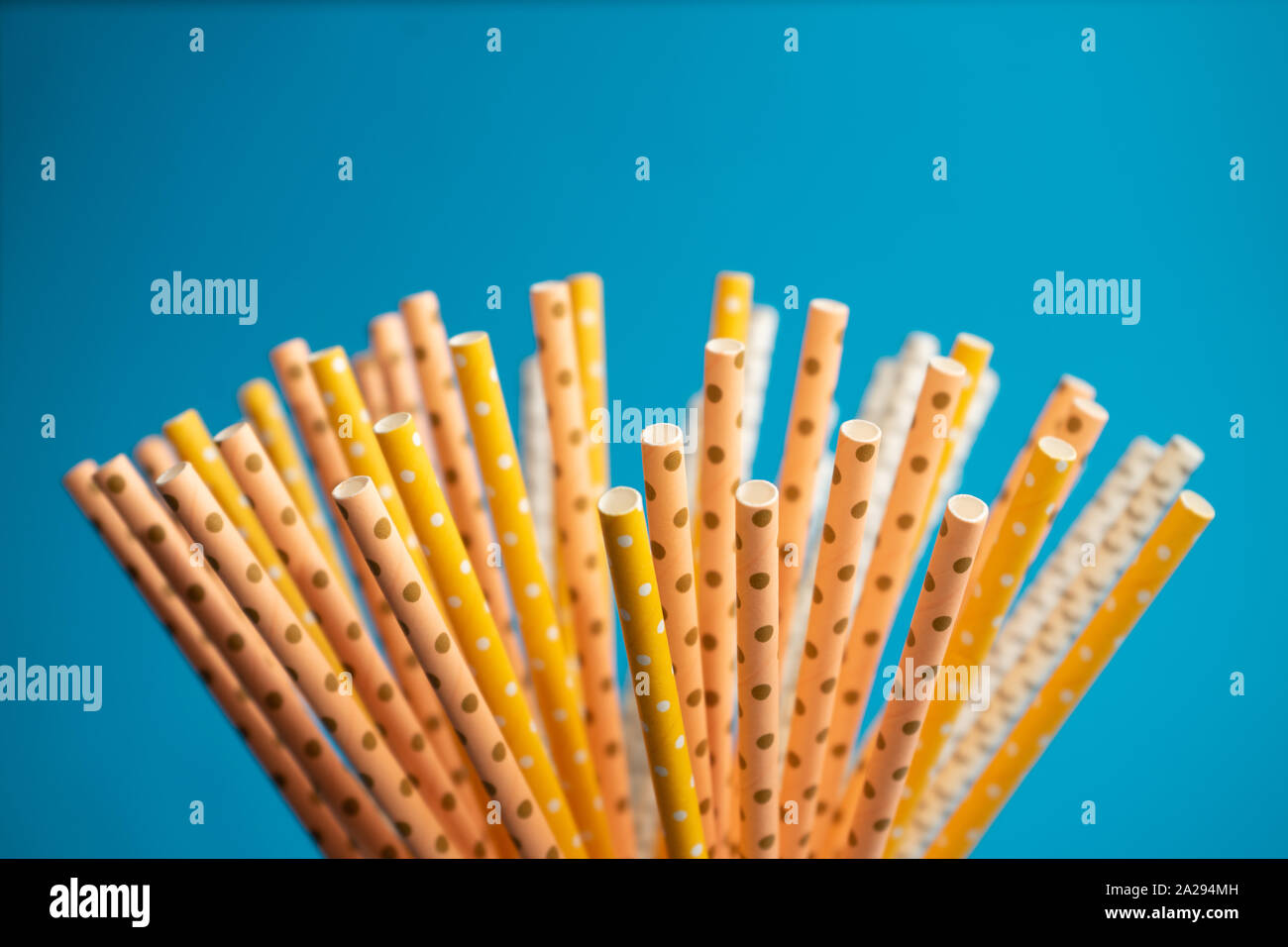 Stack of white and yellow paper straws isolated on blue background, eco friendly method, ecological way, say no to plastic anymore , copy space Stock Photo