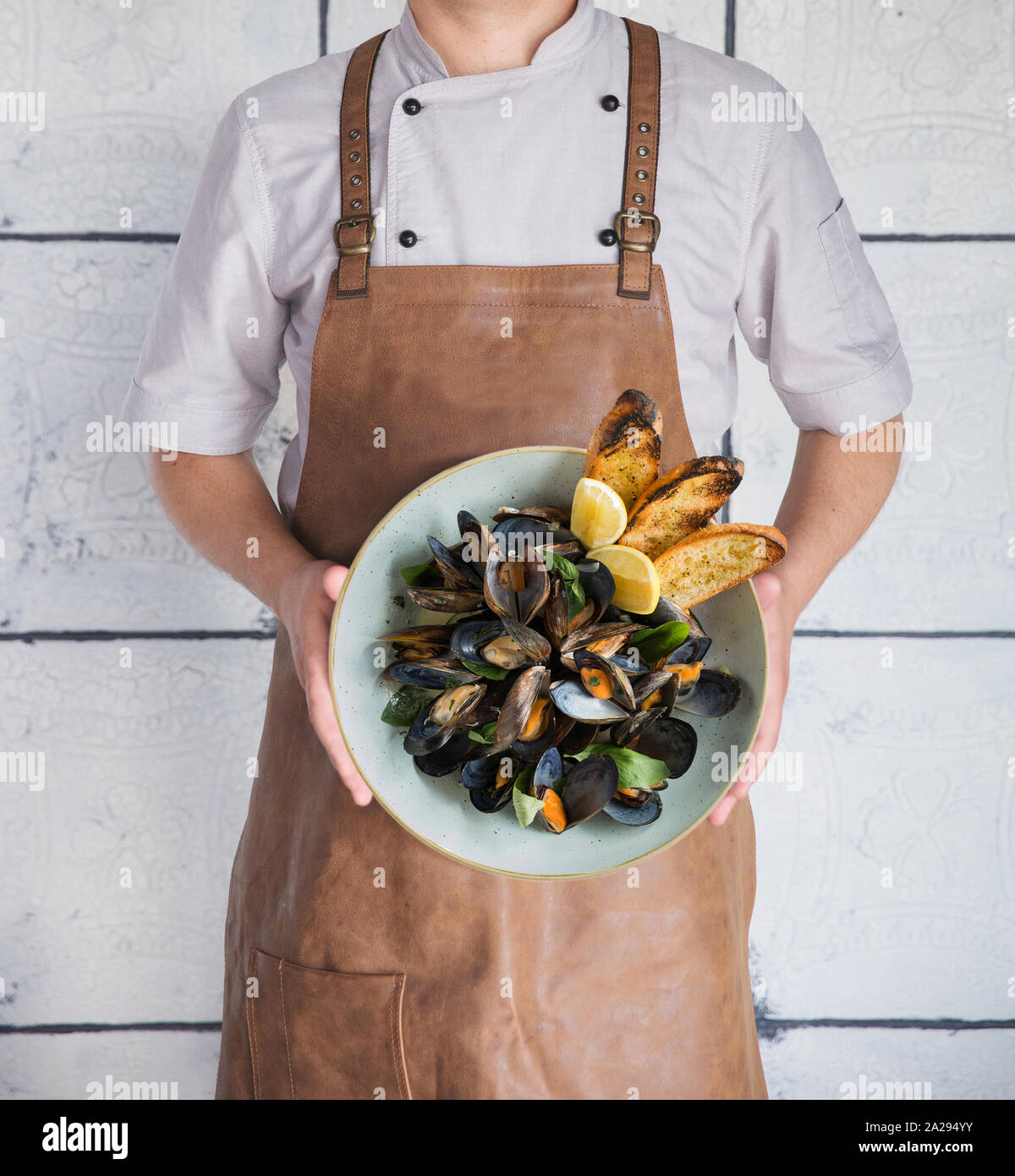 The chef keeps a plate with mussels vertically Stock Photo