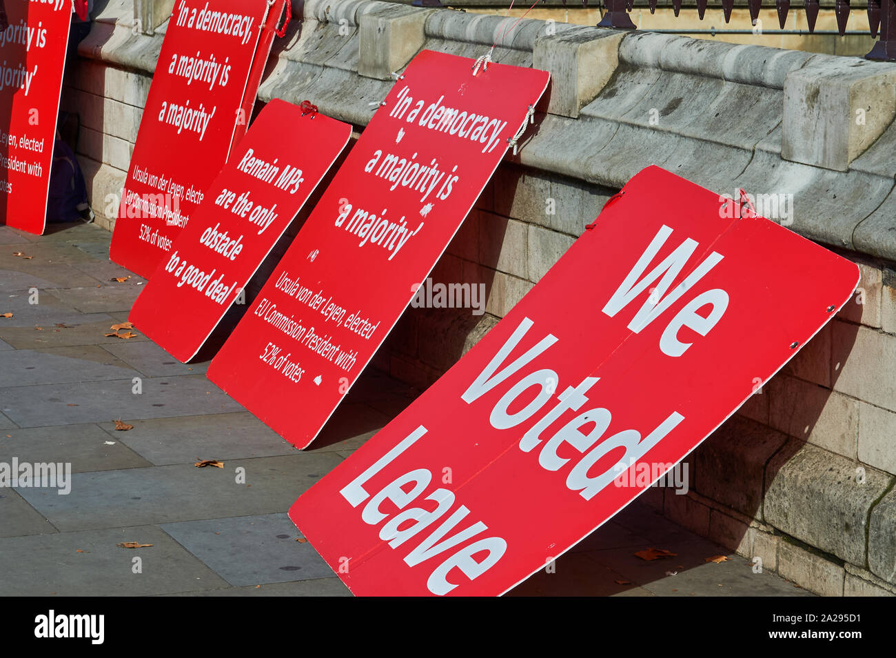 Placards in favour of leaving the European Union leaning against a wall outside the UK parliament building. Stock Photo