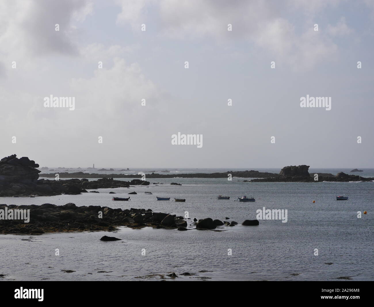 Paysage marin du Finistère , bretagne , paysage du littoral , bateaux garés derrière d'énormes rochers  , plage de galets Stock Photo