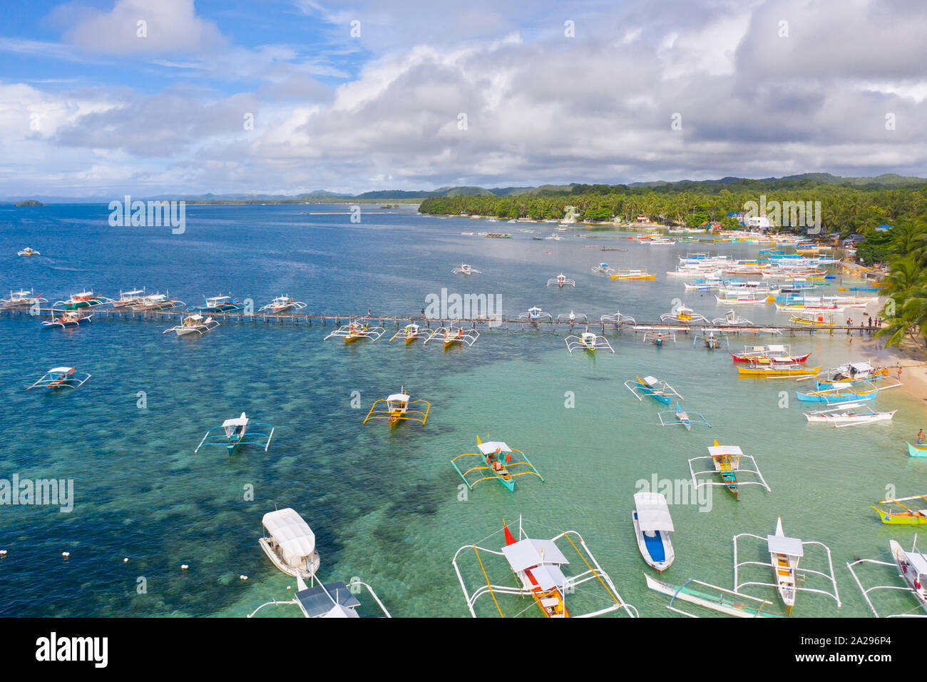 City General Luna on the coast of Siargao with a pier, a port and tourist boats. Marina with boats. Sea landscape with boats. Stock Photo