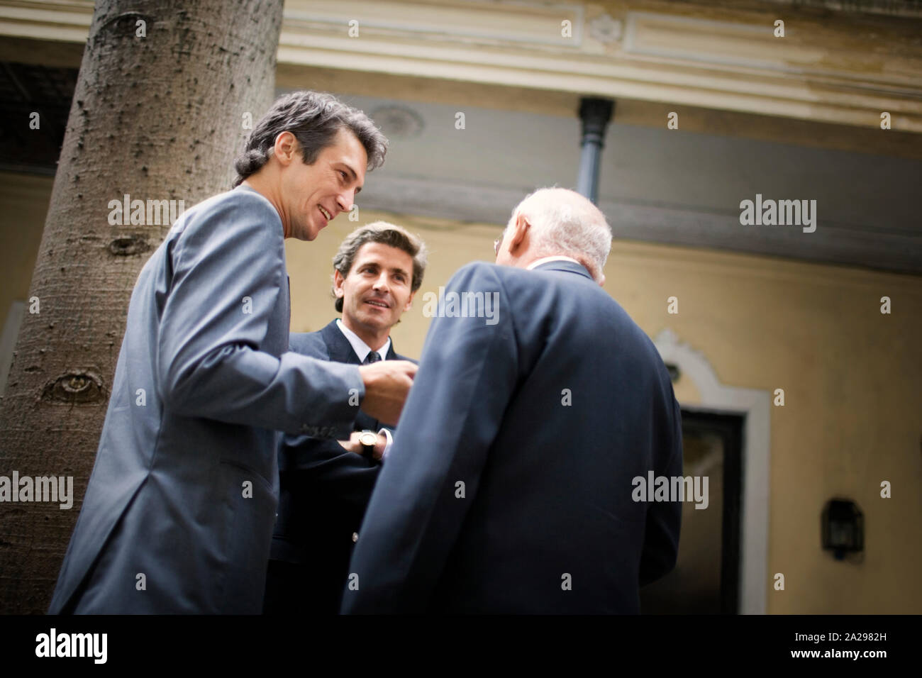 View of three men having a conversation. Stock Photo