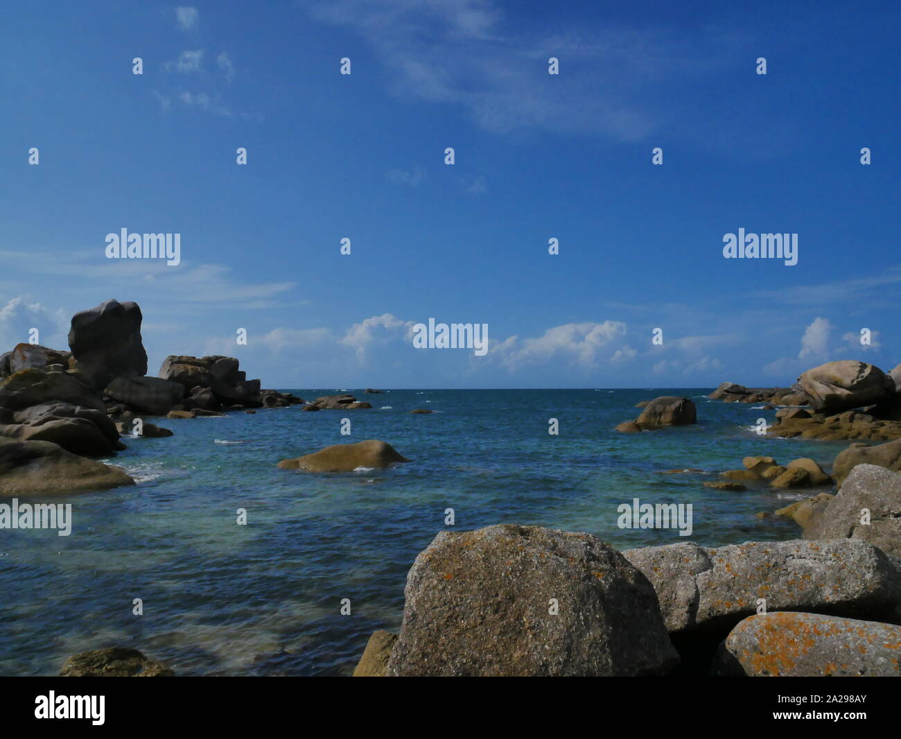 La plage de rochers en granit de meneham , avec une moutte en plein vol , eau bleu turquoise , plage de kerlouan , bretagne Stock Photo