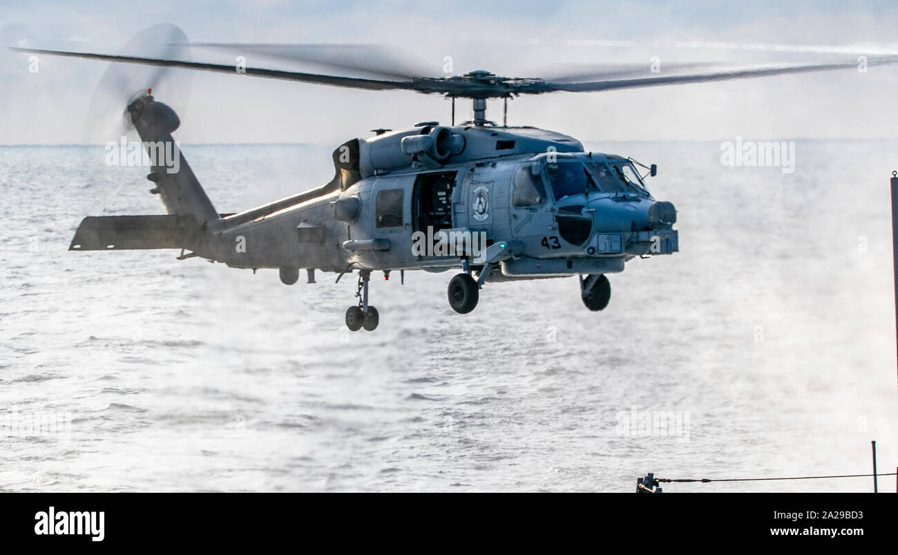 190927-N-JW440-1183 SOUTH CHINA SEA (Sept. 27, 2019) An MH-60 Sea Hawk Helicopter, assigned to the "Easyriders" of Helicopter Maritime Strike Squadron (HSM) 37, takes off from the flight deck of the Arleigh Burke-class guided-missile destroyer USS Wayne E. Meyer (DDG 108). Wayne E. Meyer is underway conducting operations in the Indo-Pacific region while assigned to Destroyer Squadron (DESRON) 15, the Navy's largest forward-deployed DESRON and the U.S. 7th Fleet's principal surface force. (U.S. Navy photo by Mass Communication Specialist 2nd Class Rawad Madanat) Stock Photo