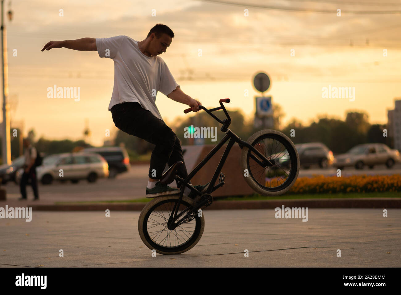 The guy stands on the front wheel of the BMX, on the parapet Stock Photo -  Alamy
